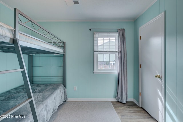 bedroom featuring crown molding and light hardwood / wood-style floors