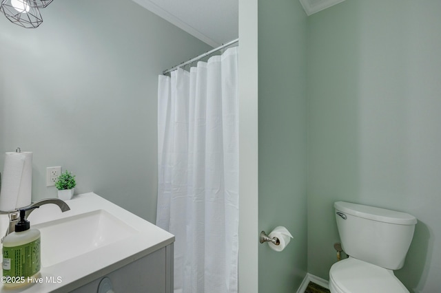 bathroom with ornamental molding, vanity, and toilet