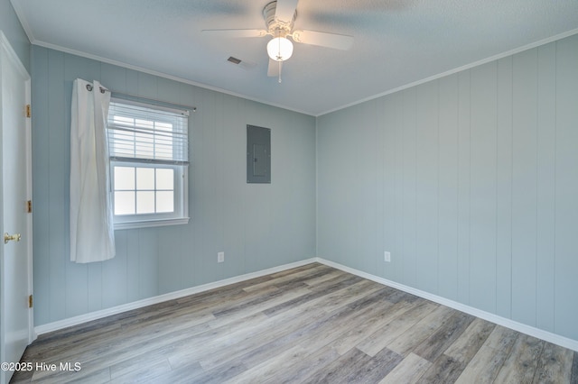 spare room with crown molding, ceiling fan, electric panel, and light wood-type flooring