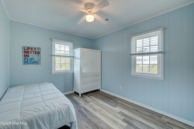 bedroom with ceiling fan, ornamental molding, and light hardwood / wood-style floors