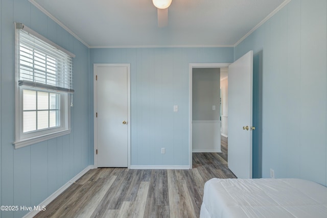 unfurnished bedroom with hardwood / wood-style floors, crown molding, and ceiling fan