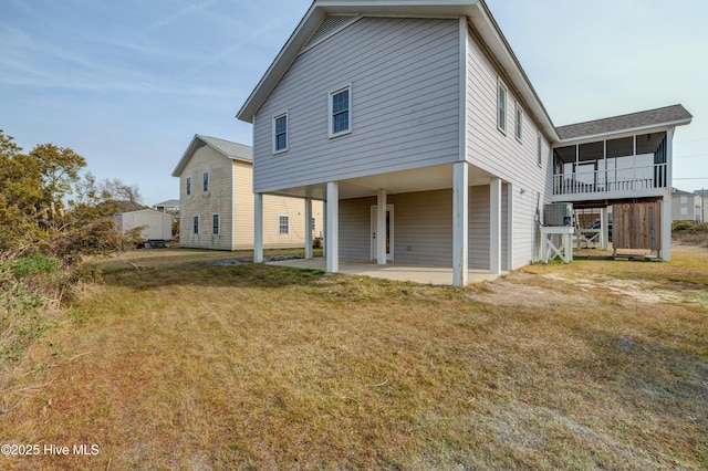 back of property featuring a sunroom, a yard, and a patio area