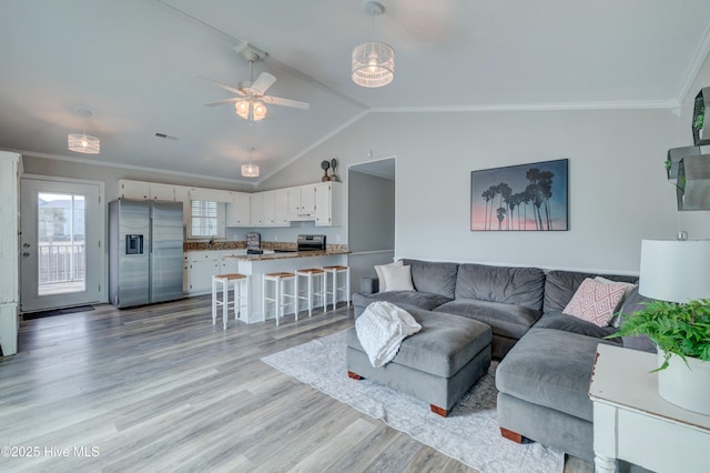 living room featuring vaulted ceiling, sink, ceiling fan, light hardwood / wood-style floors, and crown molding