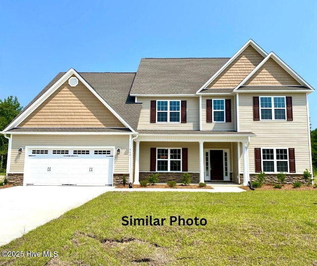 craftsman-style home with a front yard, covered porch, and a garage