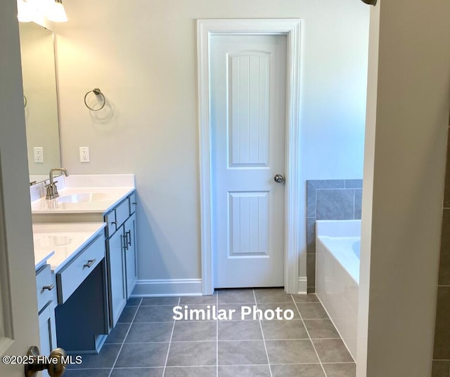 bathroom featuring vanity, tile patterned floors, and a relaxing tiled tub