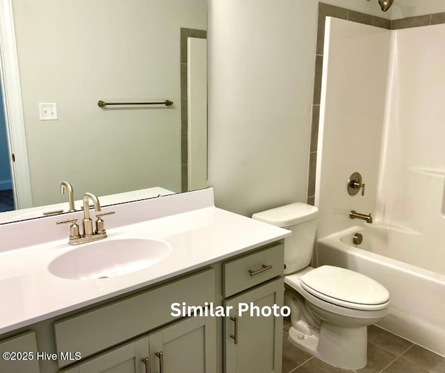 full bathroom featuring toilet, vanity, tile patterned flooring, and washtub / shower combination