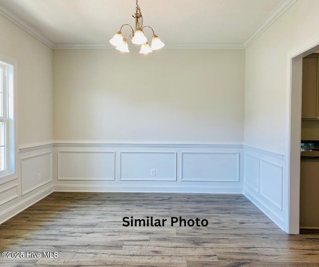 interior space featuring an inviting chandelier, ornamental molding, and light hardwood / wood-style flooring