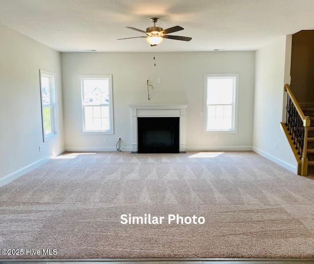 unfurnished living room featuring light carpet and ceiling fan