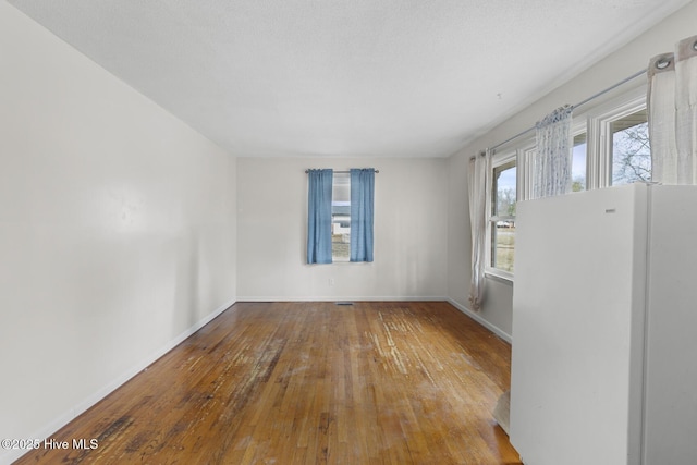 spare room with hardwood / wood-style floors and a textured ceiling