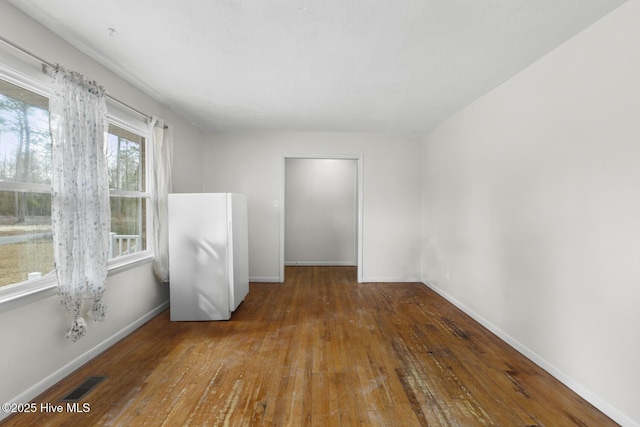 spare room with dark wood-type flooring