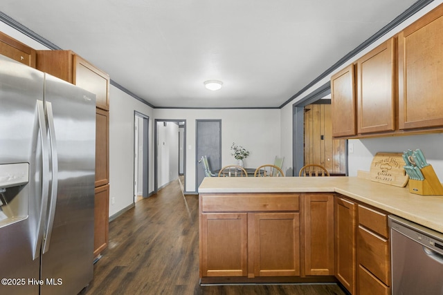 kitchen with crown molding, appliances with stainless steel finishes, dark hardwood / wood-style floors, and kitchen peninsula