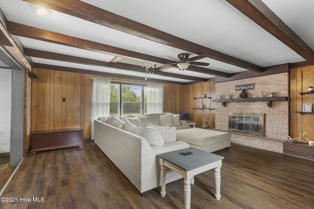 living room with ceiling fan, dark wood-type flooring, wood walls, and a fireplace