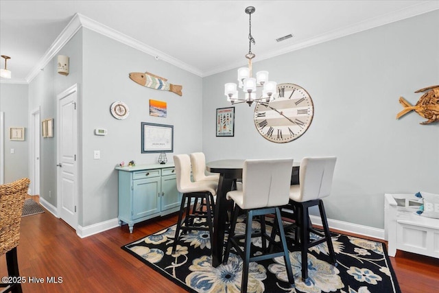 dining area with crown molding, dark wood finished floors, visible vents, and a notable chandelier