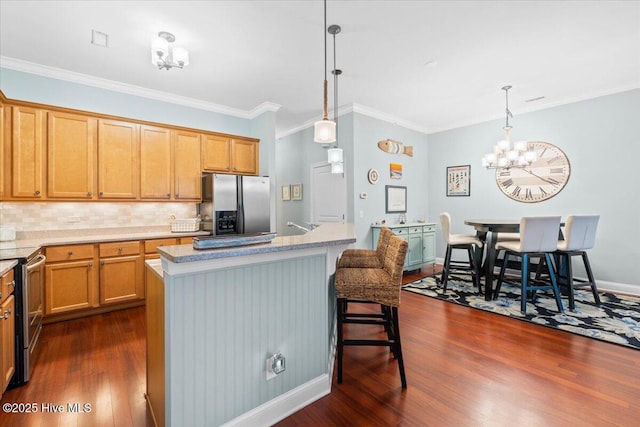 kitchen with pendant lighting, appliances with stainless steel finishes, a breakfast bar area, and a center island