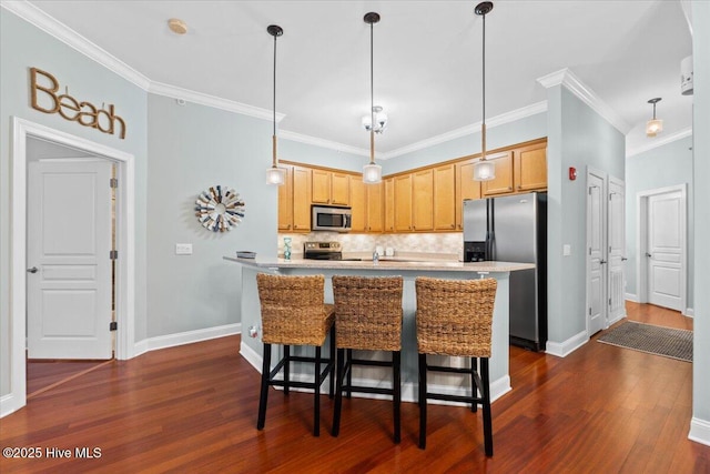 kitchen with hanging light fixtures, dark wood-style floors, appliances with stainless steel finishes, and a breakfast bar