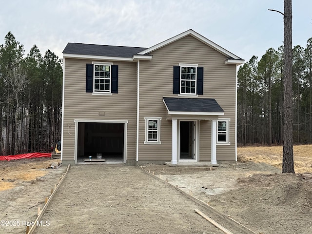 traditional-style home featuring a garage and driveway