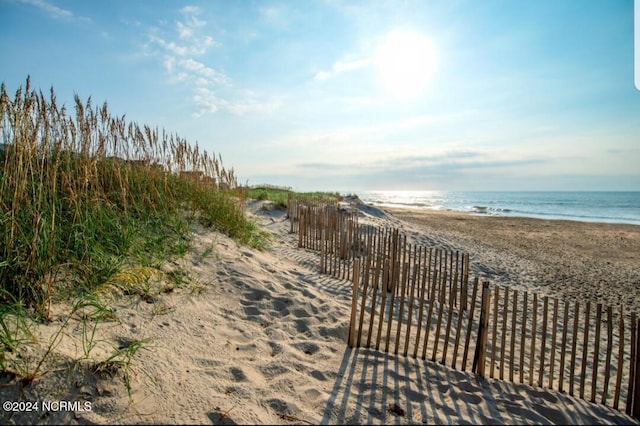 view of home's community featuring a beach view and a water view