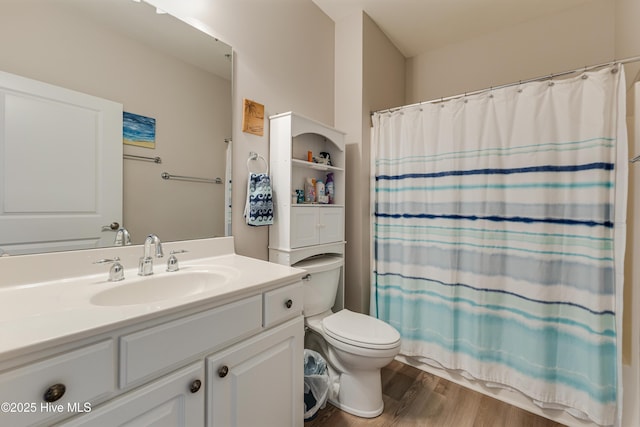 bathroom with hardwood / wood-style flooring, curtained shower, toilet, and vanity