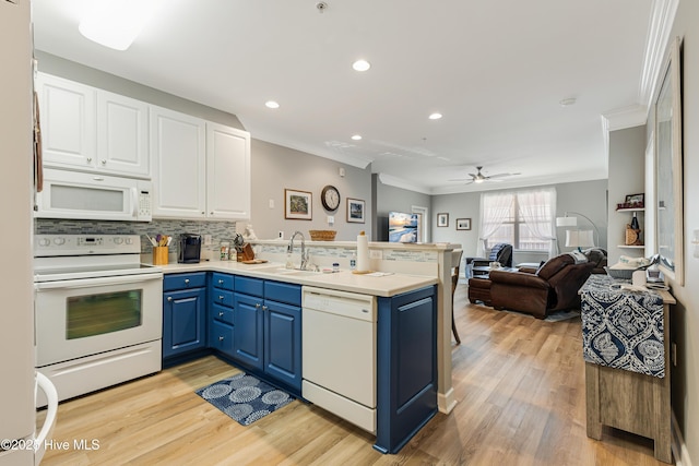 kitchen with sink, crown molding, blue cabinets, and white appliances