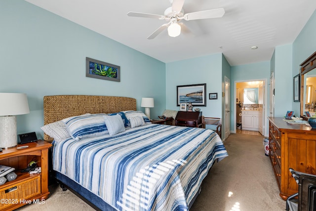 carpeted bedroom with ceiling fan and ensuite bath