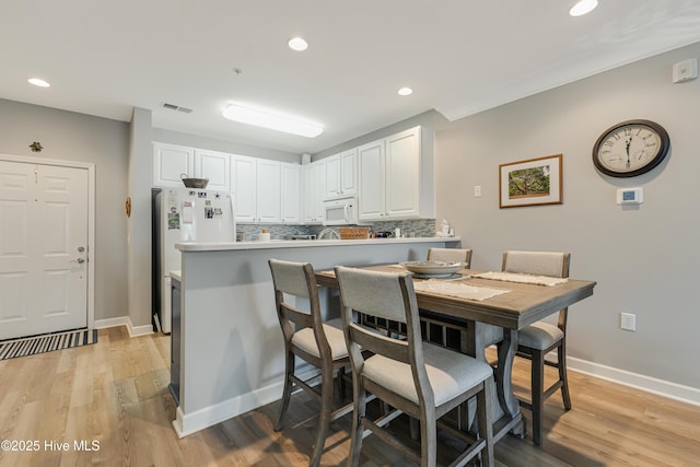 dining area featuring crown molding and light hardwood / wood-style floors