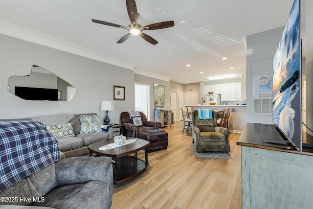 living room with light wood-type flooring, ceiling fan, and crown molding