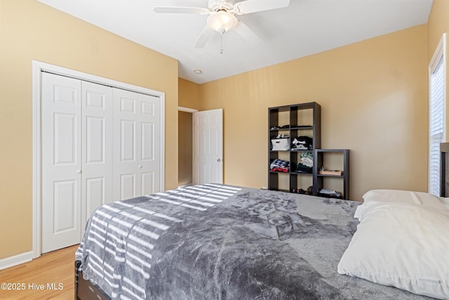 bedroom with hardwood / wood-style floors, ceiling fan, and a closet