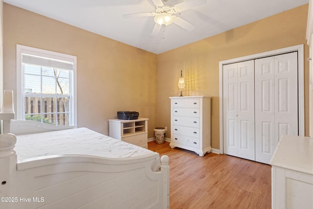 bedroom with light wood-type flooring, ceiling fan, and a closet