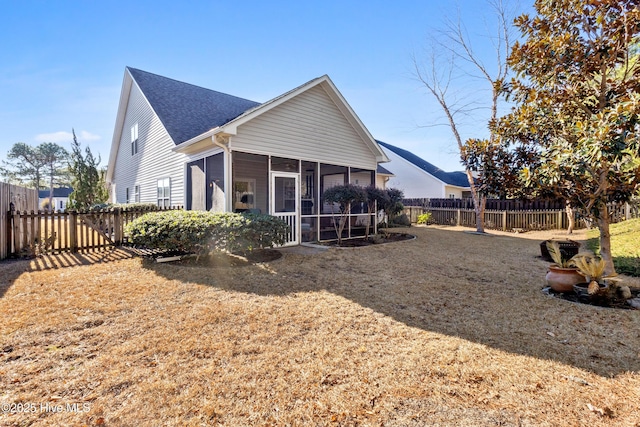 rear view of house with a sunroom and a yard