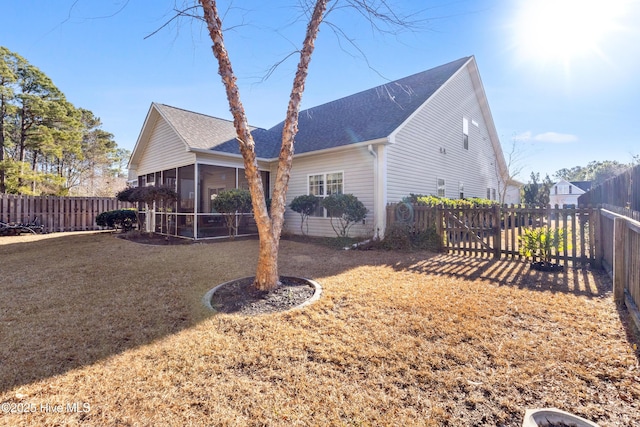 rear view of house with a sunroom and a lawn