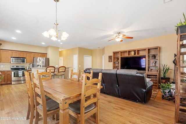 dining area featuring ceiling fan with notable chandelier and light hardwood / wood-style floors