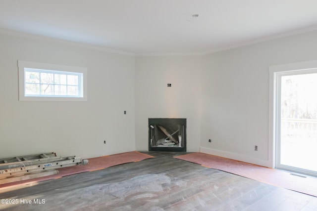 unfurnished living room with visible vents, crown molding, baseboards, and wood finished floors