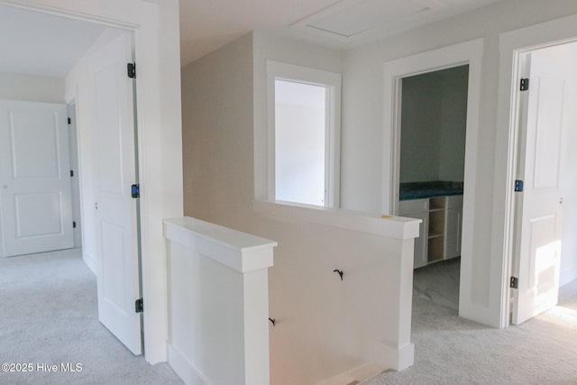 hallway featuring light colored carpet and an upstairs landing