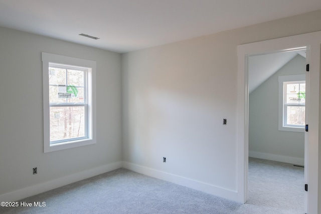 unfurnished room featuring light carpet, visible vents, and a wealth of natural light