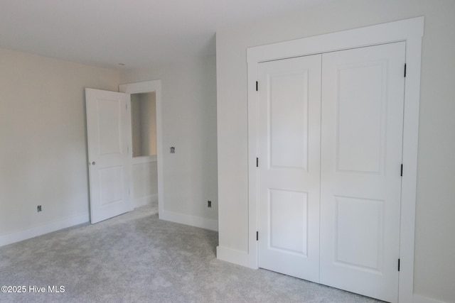 unfurnished bedroom with carpet floors, a closet, and baseboards