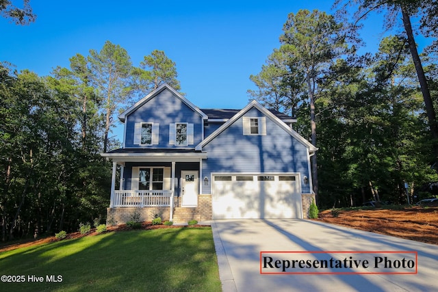 craftsman house featuring a porch, a garage, brick siding, driveway, and a front lawn