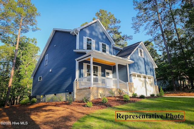 view of front of property featuring a garage, a porch, and a front yard