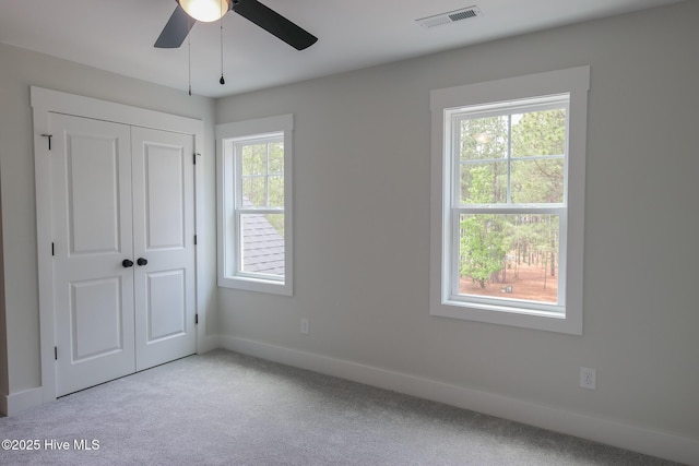 unfurnished bedroom with baseboards, carpet flooring, and a closet