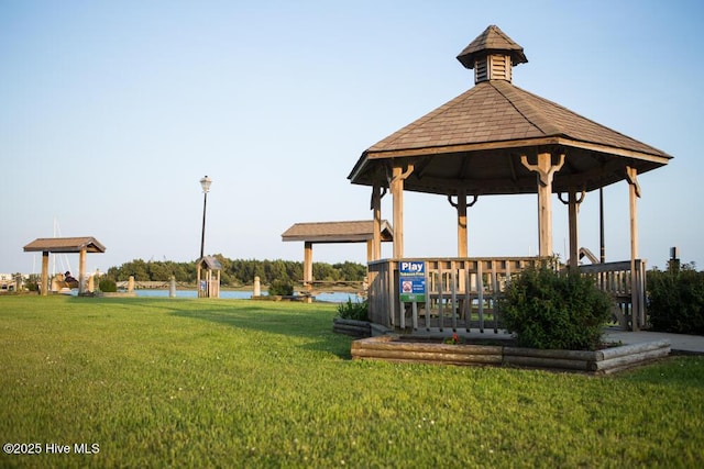 surrounding community with a gazebo, a water view, and a yard