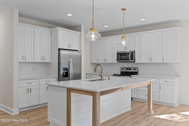 kitchen featuring hanging light fixtures, tasteful backsplash, appliances with stainless steel finishes, and white cabinets