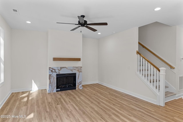 unfurnished living room with light hardwood / wood-style flooring, a fireplace, and ceiling fan