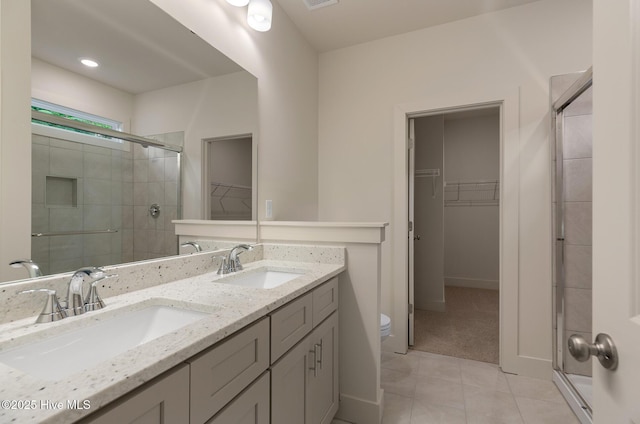 bathroom with toilet, tile patterned floors, an enclosed shower, and vanity