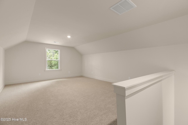 bonus room with vaulted ceiling and carpet floors