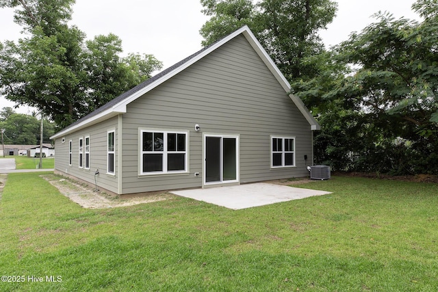 rear view of property with a patio area, cooling unit, and a lawn