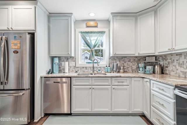 kitchen featuring white cabinetry, sink, light stone counters, and stainless steel appliances