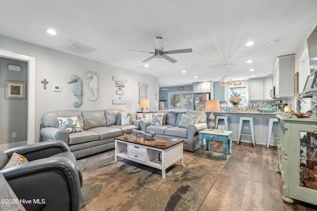 living room featuring dark wood-type flooring and ceiling fan