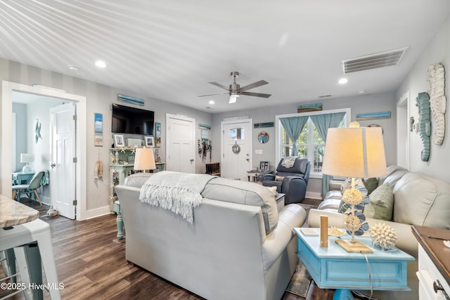 living room featuring ceiling fan and dark hardwood / wood-style flooring