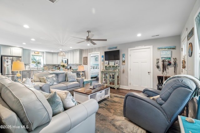 living room featuring dark wood-type flooring and ceiling fan