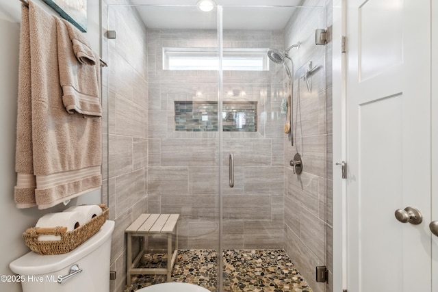 bathroom featuring an enclosed shower and toilet