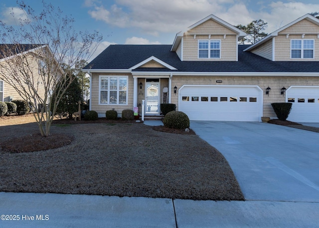 view of front facade with concrete driveway, an attached garage, and a shingled roof